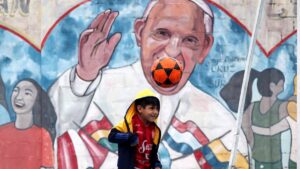 A child plays in front of a Pope Francis mural at the Iglesia of 'Cristo Obrero' football field, Buenos Aires, Argentina, April 14, 2024. (Getty Images Photo)