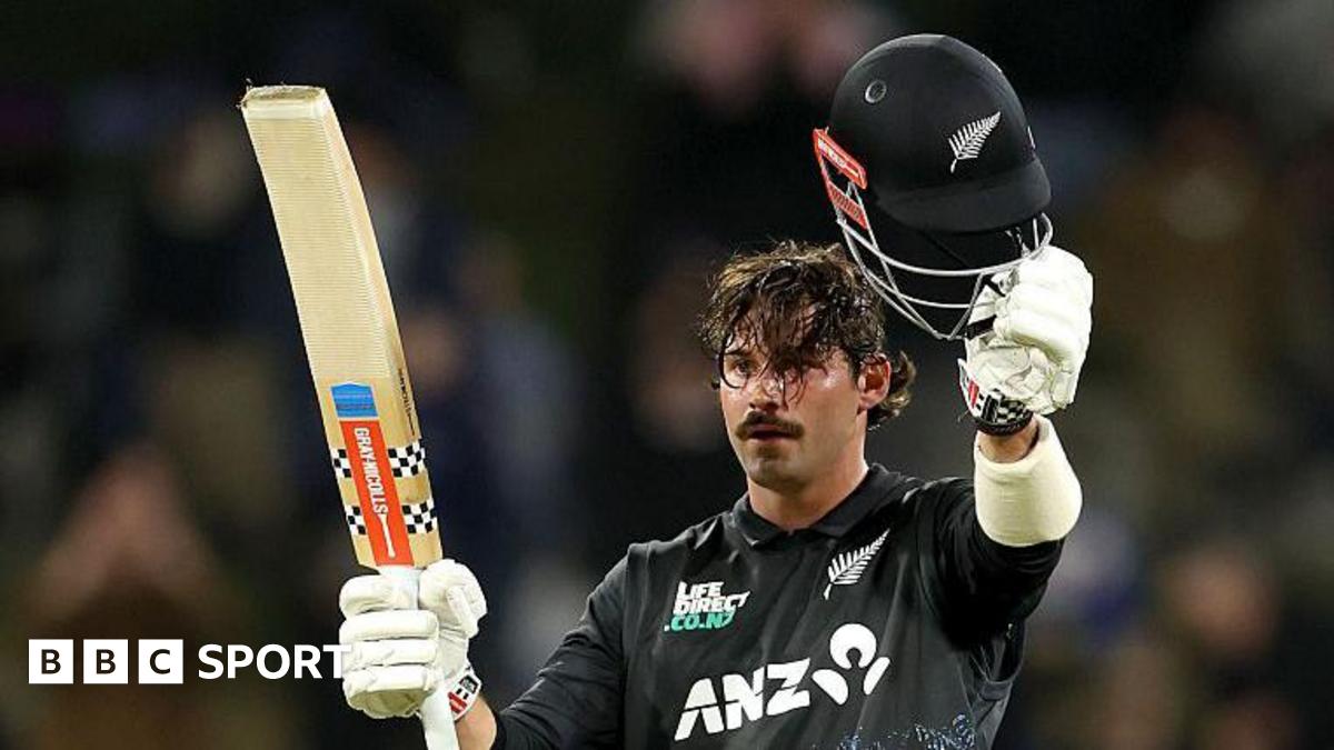Tim Robinson raises his bat and helmet after reaching his century