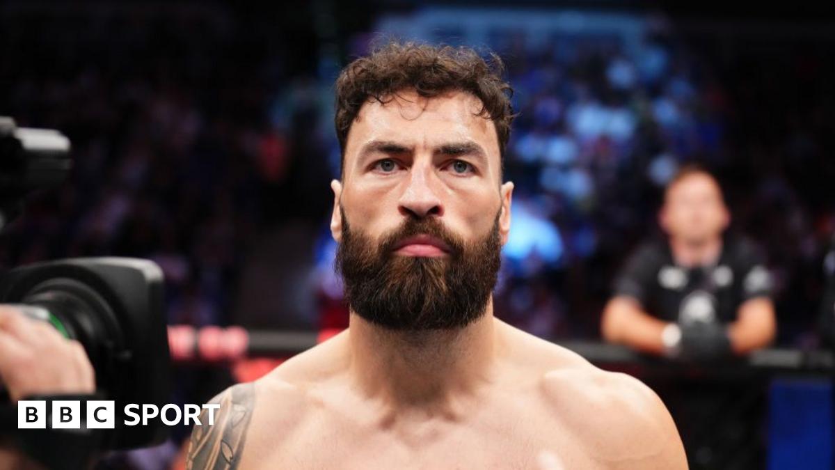 Alex Pereira, with red face paint and wearing a native hat of Brazil, faces off Magomed Ankalaev